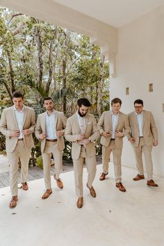 a group of men in suits standing next to each other on a white tiled floor