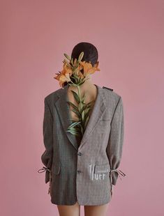 a mannequin wearing a suit with flowers on it's head and neck