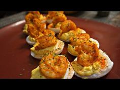 deviled eggs stuffed with shrimp and cheese on a red plate, ready to be eaten