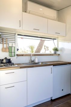 a kitchen with white cabinets and wooden counter tops