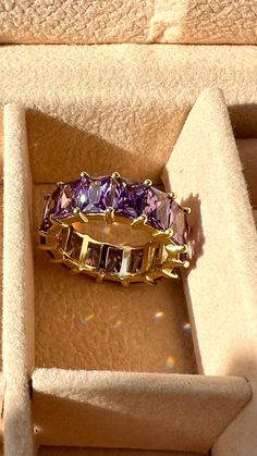 Gold plated Amethyst eternity band , gold stackable amethyst ring , February birthstone jewelry, gift for her , Christmas gift , holiday gift  Elevate your holiday gifting with our exquisite gold plated amethyst eternity band . This timeless piece seamlessly blends the warmth of gold with the enchanting beauty of amethyst, creating a ring that symbolizes everlasting elegance. Crafted with precision, this band is a perfect addition to festive celebrations or a thoughtful gift for someone special. Embrace the magic of the season with this stunning accessory that captures the esseof joy and sophistication.  Material  . 14 K gold plated  . 925 Sterling Silver  . Purple cubic zirconia  Size  .6 US  Feel free to send me a message if you would like a different ring size !  Thank you so much for t Stackable Emerald-cut Cubic Zirconia Eternity Band, Stackable Emerald Cut Eternity Band For Promise Ring, Emerald Cut Eternity Band With Vvs Clarity As Gift, Elegant Emerald-cut Gemstone Eternity Band, Emerald Cut Eternity Band With Vvs Clarity, Fine Jewelry Stackable Eternity Band Gift, Gold Stackable Emerald Cut Eternity Band, Elegant Stackable Adjustable Amethyst Ring, Stackable Cubic Zirconia Jewelry With Emerald Cut