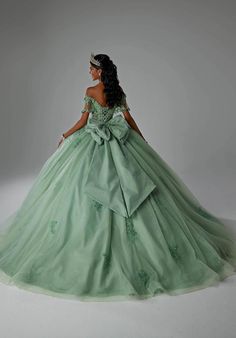 a woman in a green ball gown standing on a white background