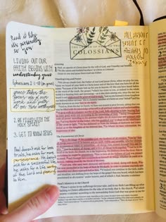 a hand holding an open book with writing on it and notes about the church's history