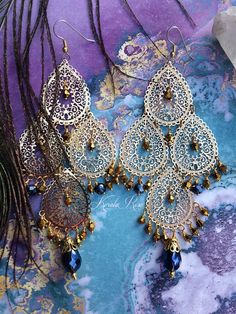 "This pair of Handmade Chandelier Earrings is made with 3 tiers of lacy gold plated filigrees. Metallic Gold and Montana Blue crystal beads dangle from the design. Pierced with french wires (as shown), clip-ons, leverbacks or posts, just select from the pull-down menu. -5 1/4\" Long x 2\" Wide -0.4 oz. ea. Metal Finishes Available: -Gold(as pictured) -Silver *Comes Ready To Gift in Decorative Packaging *Each Pair is Made Just for You! -For FAQ's & Earring Weight Scale, please click on the \" Luxury Tilla Chandelier Earrings For Festivals, Luxury Meenakari Temple Jewelry Chandelier Earrings, Bohemian Teardrop Chandelier Earrings With Filigree, Bohemian Teardrop Filigree Chandelier Earrings, Bohemian Chandelier Earrings With Filigree For Parties, Gold Bohemian Chandelier Earrings With Dangling Beads, Bohemian Gold Dangle Chandelier Earrings, Gold Bohemian Dangle Chandelier Earrings, Bohemian Gold Teardrop Earrings For Party