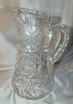 a clear glass pitcher sitting on top of a white cloth