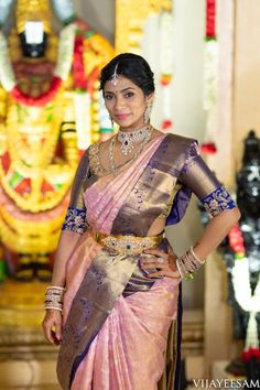 a woman in a pink and gold sari