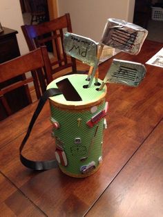 a green trash can sitting on top of a wooden table