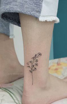 a small flower tattoo on the ankle