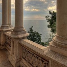 an old building with columns overlooking the ocean