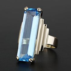 Vintage 14k Yellow Gold Art Deco Swiss Blue Topaz Anniversary / Cocktail Ring This Beautiful Vintage Art Deco Ring Is Made Of 14 Karat Yellow Gold Featuring A Rectangle-Cut Blue Topaz Set In A Prong Setting. This Ring Is A Size 6.5 Although It Can Be Re-Sized If Needed By A Qualified Jeweler. It Weighs A Total Of 4.89 Dwt Which Is Equivalent To 7.61 Grams. This Ring Is Perfect For A Cocktail Ring Or Even An Anniversary Ring. Please Keep In Mind That On The Stone Top There Are Light Scratches. Also Note That This Ring Is Stamped On The Inner Band With "14k." This Ring Gives Off The Drama And Classiness All In One. Size: 6.5 Stamped: "14k" Metal: 14 Karat Yellow Gold Weight: 4.89 Dwt // 7. Modern Blue Topaz Ring For Formal Occasions, Formal Blue Topaz Ring With Baguette Cut, Formal Baguette-cut Blue Topaz Ring, Formal Baguette Cut Blue Topaz Ring, Formal 14k Gold Baguette Cut Topaz Ring, Blue Topaz Baguette Cut Ring In 14k Gold, Formal Baguette Cut Topaz Ring In 14k Gold, Art Deco Blue Topaz Ring With Accent Stones, Yellow Gold Blue Topaz Baguette Cut Ring