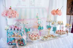 a table topped with lots of cakes and cupcakes