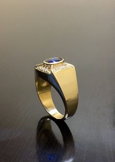 DeKara Designs Classic PICTURES DO NO JUSTICE ON THIS RING! This Ring Has Exceptional Quality From Design To the Sapphires, Diamonds and Gold. Metal- 18K Yellow Gold, .750, Stones- 1 Oval Ceylon Blue Sapphire 1.20 Carats. 12 Round Diamonds G-H Color VS2 Clarity 0.25 Carats. Art Deco Inspired 18K Yellow Gold Blue Sapphire Diamond Engagement Ring. This ring features two beautifully colored fiery Ceylon Blue Sapphire that is oval in shape and bezel set professionally. The sapphire is surrounded by Modern Yellow Gold Sapphire Ring For Formal Events, Modern Yellow Gold Sapphire Ring For Formal Occasions, Luxury Sapphire Diamond Ring With Polished Finish, Modern Sapphire Signet Ring For Anniversary, Luxury Marquise Cut Sapphire Ring, Luxury Sapphire Signet Ring, Luxury Yellow Gold Sapphire Ring With Diamond Cut, Luxury Sapphire Signet Ring For Formal Occasions, Luxury 14k Stamped Sapphire Ring