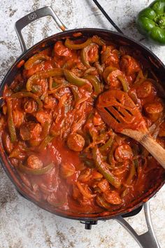 a skillet filled with red sauce and green peppers