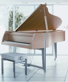 a grand piano sitting on top of a white tiled floor next to a vase filled with flowers