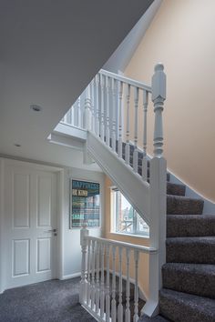 a staircase leading up to the second floor in a house with carpeted floors and white railings