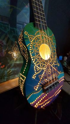 a colorful guitar is lit up in the dark