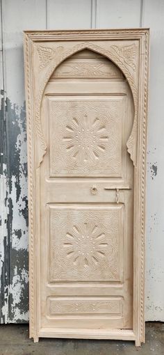 an old wooden door with intricate carvings on the front and side doors, painted white