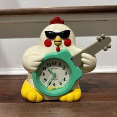 a chicken clock with sunglasses on its face holding a skateboard in front of it