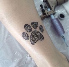 a dog paw tattoo on the arm