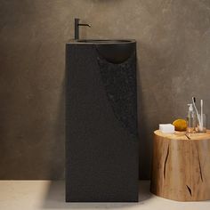 a bathroom sink sitting on top of a wooden stump next to a mirror and soap dispenser