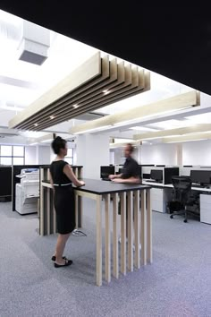 two people standing at a desk in an office