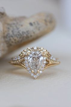 a close up of a ring with a diamond in the middle and a branch behind it