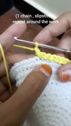 someone is crocheting the stitchs on their hand knitted hat with yellow yarn