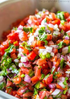 a white bowl filled with chopped red onions and green peppers, garnished with cilantro