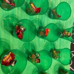 several green cups filled with candy on top of a table