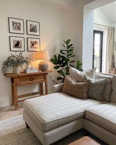 a living room filled with furniture and pictures hanging on the wall above it's windows