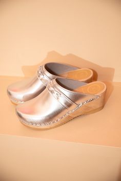 The Bridget Clog by No.6 is a slip on, closed toe clog with a gentle braided band detail across the top. A comfortable mid-wedge base is lightweight and lends stability to the open-back style, featuring a rounded toe box and stitched collar. This No.6 classic is nuanced in the details, perfectly paired with any bottom. Wear with socks in the colder months. Since its advent in 2005, No.6 has garnered a cult following for its versatile staples like the handmade clog shoe. It has since evolved into Clog Shoe, Subtle Luxury, No 6, Sustainable Practices, Clogs Shoes, Womens Clogs, Cow Leather, Clothes For Sale, Clogs