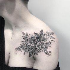 a woman's chest with flowers and leaves tattooed on her left side ribcage