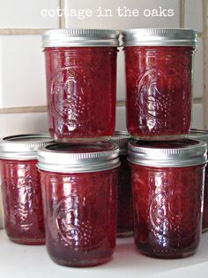 several jars filled with red liquid sitting on top of a counter