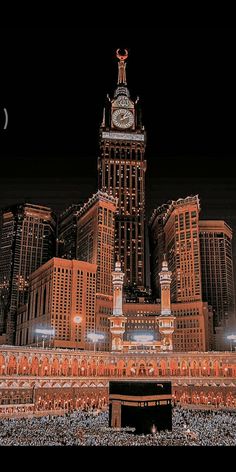 a large clock tower in the middle of a city with tall buildings behind it at night