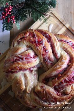 cranberry swirl bread with icing on a cutting board next to christmas decorations