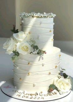 a wedding cake with white flowers and greenery