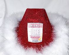 a red hat with white fur around it on top of a white sheeted surface