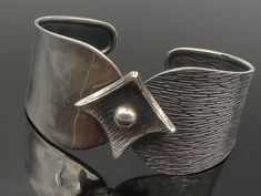 925 Sterling Silver - Vintage Dark Tone Flower Motif Cuff Bracelet - BT5432  925 Sterling Silver - Vintage Dark Tone Flower Motif Cuff Bracelet - BT5432  Jewelry Type:         Bracelet  Metal Type:            925 Silver  Metal Size:             7" Length  1.25" Height   Stone Type:            N/A  Condition:              N/A  Jewelry Weight:     21.2 Grams  PLEASE NOTE: THIS ITEM IS PRE-OWNED. ALTHOUGH MOST ITEMS ARE IN VERY GOOD CONDITION, SOME MAY NEED CLEANING AND/OR MINOR REPAIRS. WE MAKE A Silver Modernist Bangle As Gift, Contemporary Silver Cuff Jewelry, Modernist Silver Bangle For Gift, Silver Artistic Bracelets For Formal Occasions, Artistic Silver Bracelets For Formal Occasions, Contemporary Silver Cuff Bracelets, Bracelet Metal, Luxe Jewelry, Silver Jewelry Design