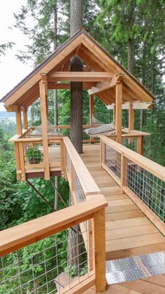 a wooden deck with hammocks in the trees and on the other side is a tree house