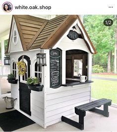 a small white dog house with a chalkboard sign on the front door and windows