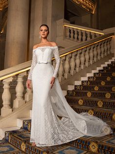 a woman in a wedding dress standing on some stairs