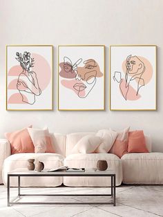 three abstract paintings hang on the wall above a white couch and coffee table in a living room