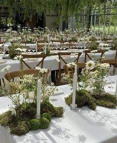 tables with white tablecloths covered in flowers and greenery