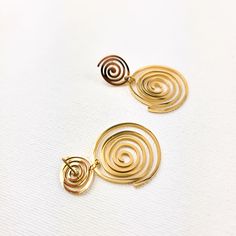 The Milena Drop Earrings combine contemporary design with artisanal craftsmanship. Crafted from stainless steel and plated in gold, they showcase a mesmerizing spiral motif that exudes sophistication. Whether worn casually or for a chic evening look, these earrings elevate any ensemble with their modern elegance. Make a swirly statement with the Milena Drop Earrings and add a timeless piece to your jewelry collection. Material: Stainless Steel - 18 k Gold plated Size: approx. H: 2 in x approx. W Elegant Spiral Gold Plated Earrings, Handmade Elegant Spiral Earrings, Elegant Swirl Hoop Earrings As Gift, Elegant Handmade Spiral Earrings, Elegant Gold Spiral Wrap Earrings, Elegant Handmade Swirl Earrings, Gold-plated Spiral Earrings For Gift, Gold Plated Spiral Earrings For Gift, Gold Plated Spiral Earrings As Gift