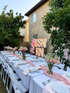 a long table set up with plates and flowers