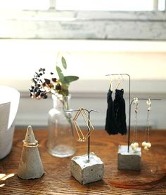 several different types of earrings on display in front of a window with flowers and other items