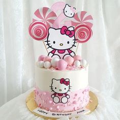 a hello kitty birthday cake with lollipops on top