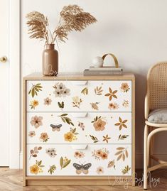 a dresser with flowers and butterflies painted on it