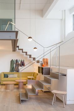 a living room filled with furniture next to a stair case