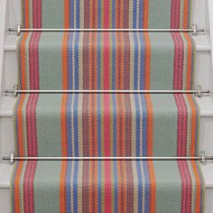 the stairs are covered with colorful striped carpet